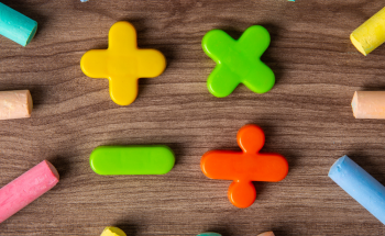 Mathematical symbols and coloured chalks on a table