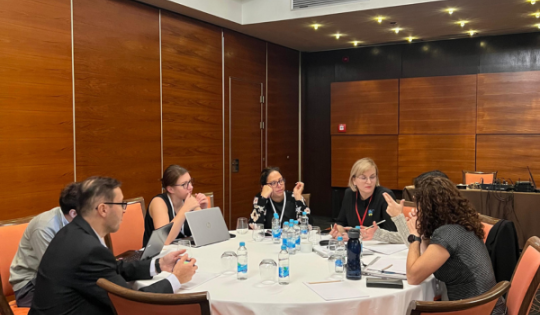 Teachers discussing, sitting at a table 