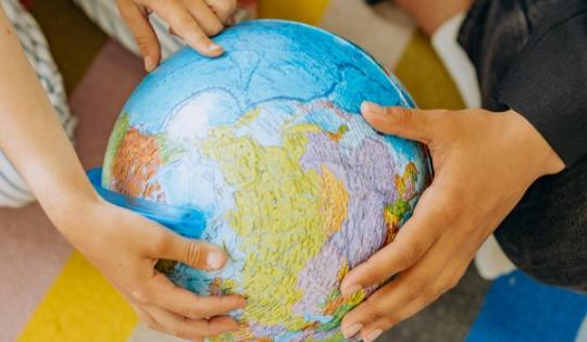 Children's hands holding a globe